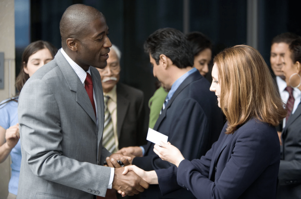 two business people exchanging business cards at networking event